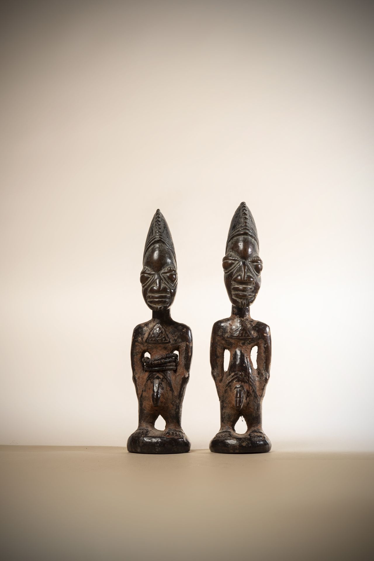 Null YORUBA (尼日利亚)

一对戴着三角胸饰的Ibedji双胞胎，深色的漆面和痕迹

红赭色的坎木

前阿兰-普罗沃特收藏

高度：30和31厘米