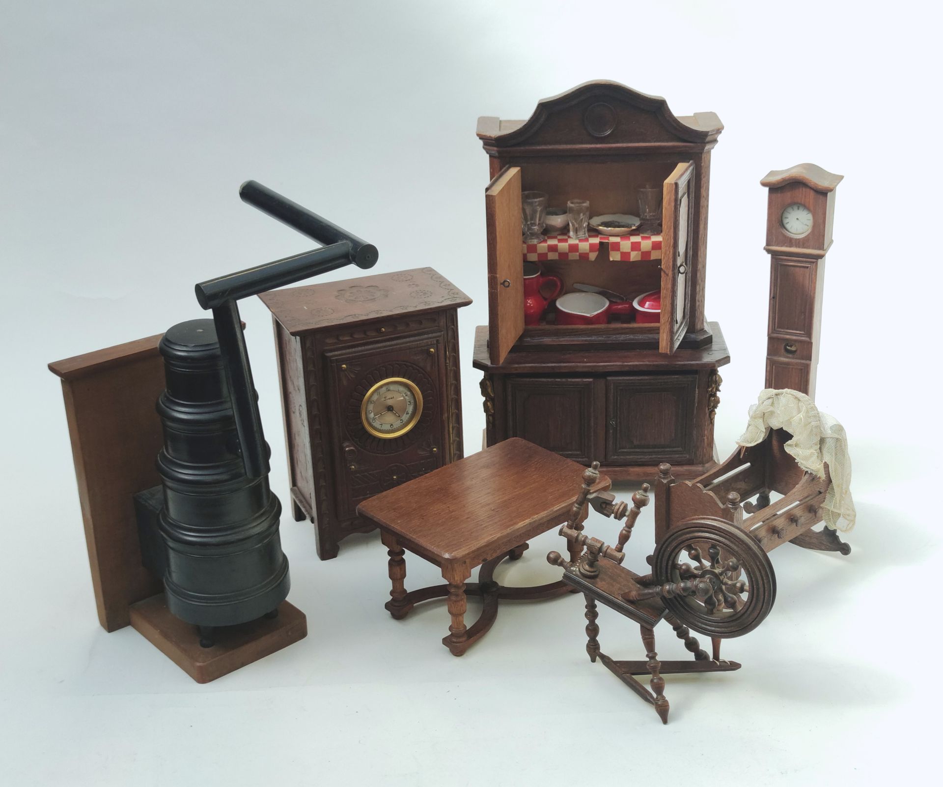 Null 
一套娃娃家具，包括一个双层餐具柜，一张桌子，一个落地钟和一个无底的摇篮，一个纺车，和一个时钟，一个发黑的木炉子