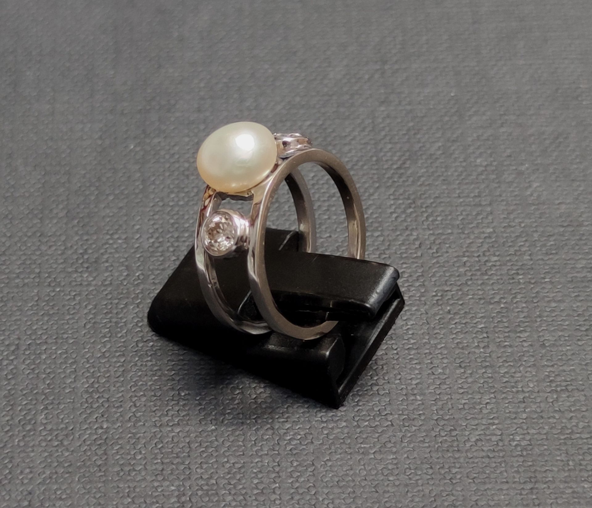 Null RING AUS 750°/00 GRAUGOLD, besetzt mit einer Perle und zwei Diamanten. 

Br&hellip;
