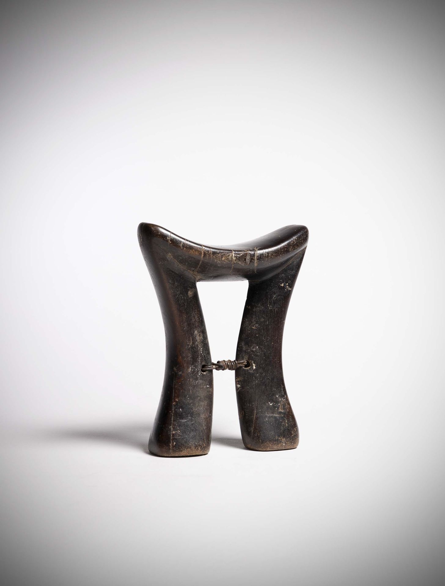 Null Karamojong

(乌干达）沉重的木制颈托，有很深的使用痕迹。

两只脚在中间高度处用铁丝缠绕连接起来。

深深的使用痕迹。高：18厘米
