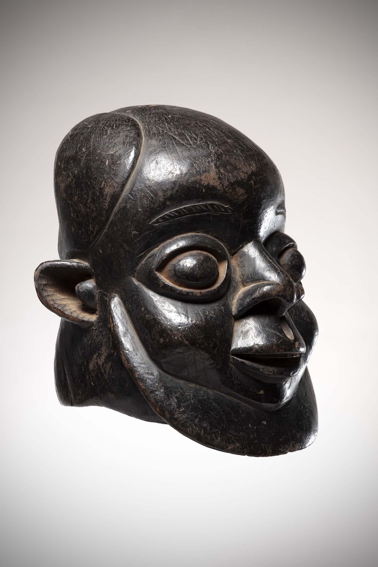 Null Békom

(喀麦隆)男性头盔面具，有深黑色铜锈。

在空腔中（眼睛、嘴巴、耳朵，残留着红赭石凸起的痕迹）。高：29厘米