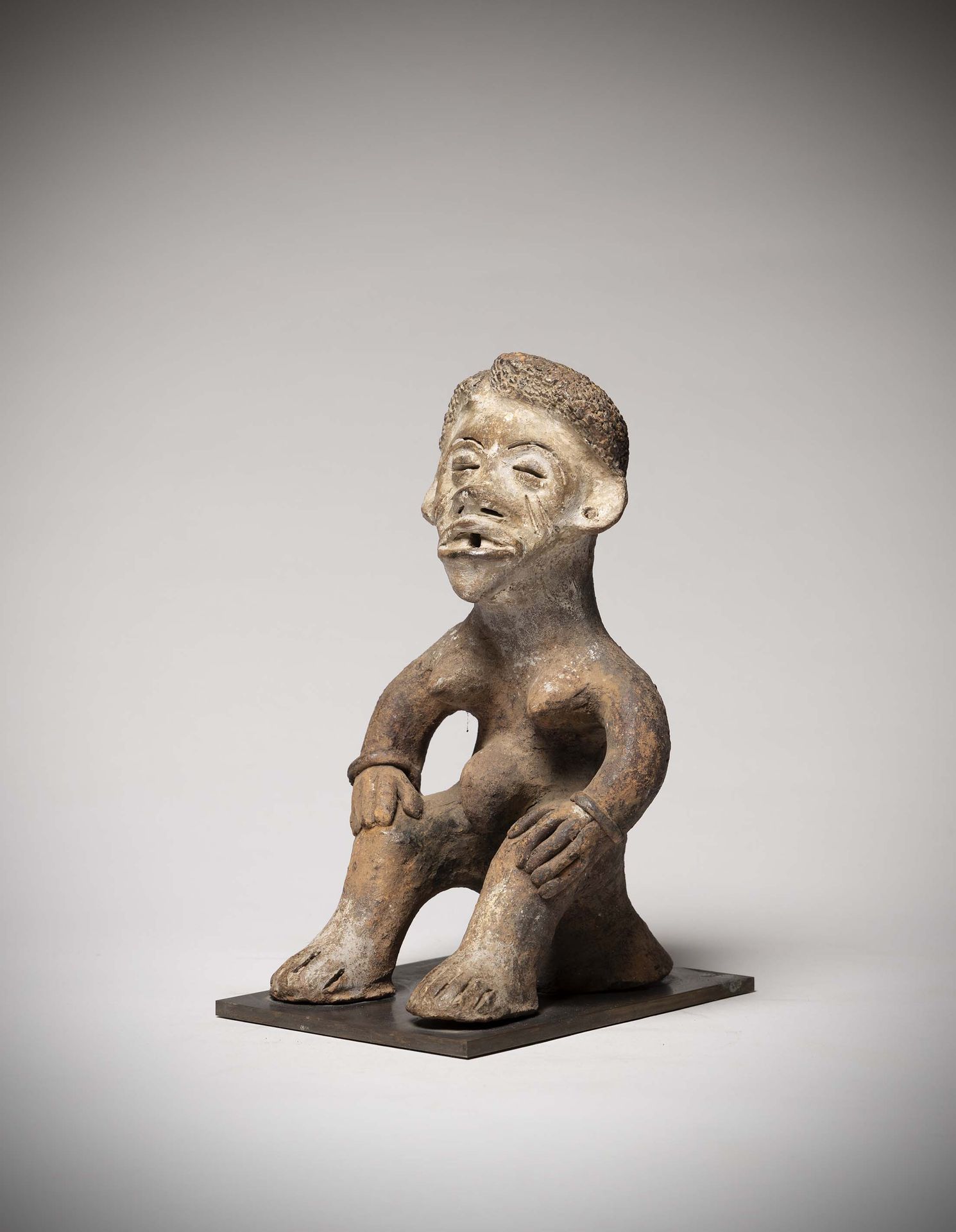 Null 伊博

(尼日利亚) 祭坛雕像，陶制，代表一个坐姿的女人，双手放在膝盖上。

注意这个雕塑的保存状况非常好。高：25.5厘米