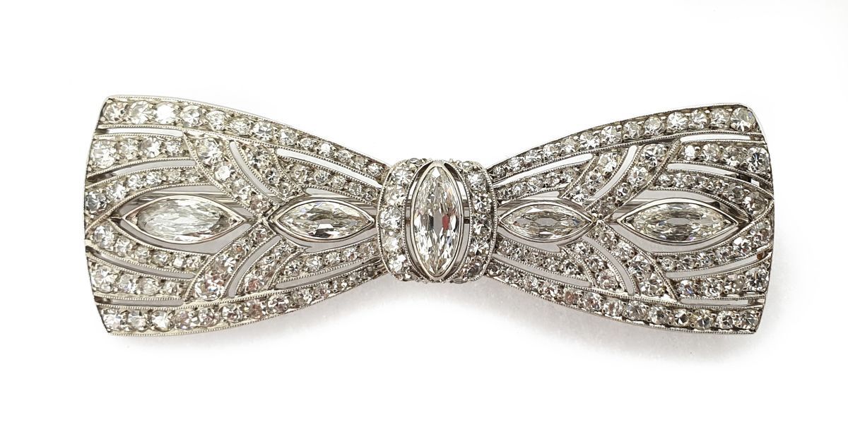 Broche noeud A platinum brooch set with pear-cut and 8/8 diamonds.