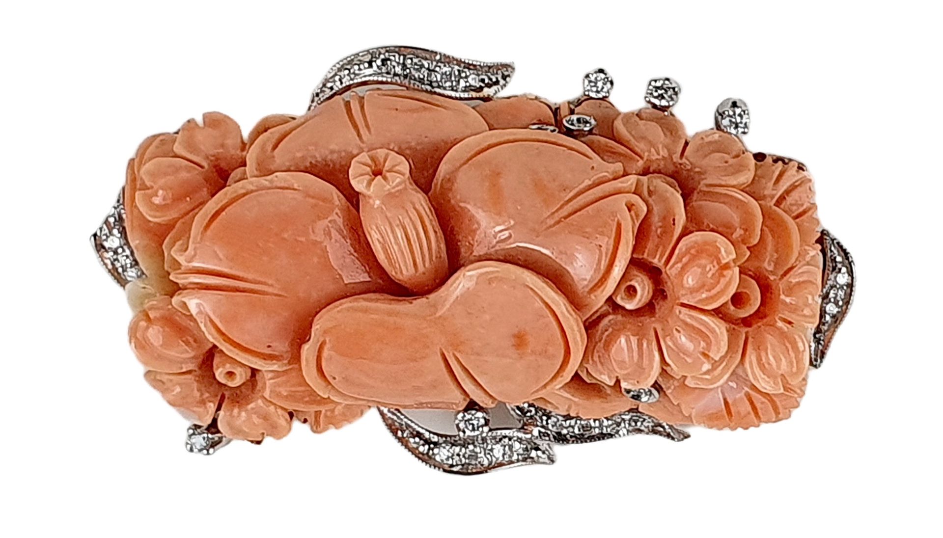 Broche pendentif 18K(750)白金，安装在粉红珊瑚上，上面刻有花纹，周围是铺有钻石的涡旋，可转换为吊坠。

毛重：25.3克 - 长度：5.&hellip;