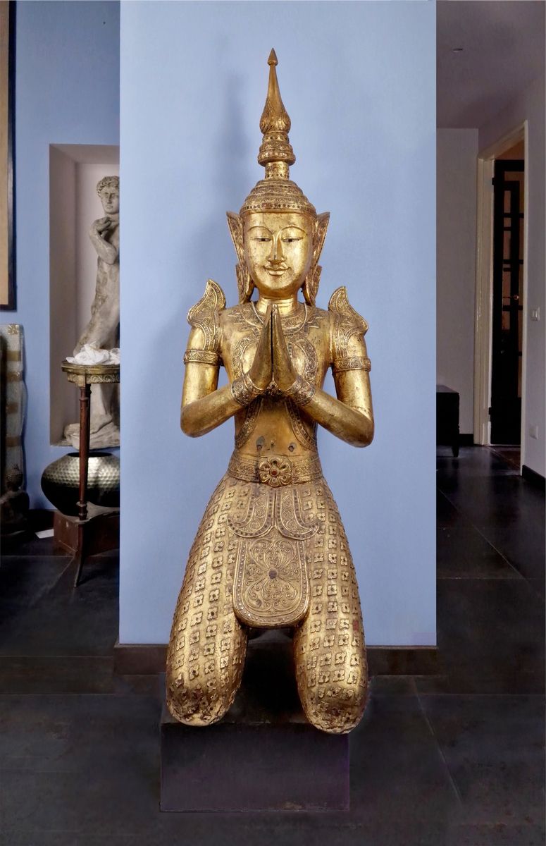 TRES IMPORTANT BOUDDHA, THAILANDE 雕刻和镀金的木头，有镶嵌物，代表一个跪着的神人，双手在祈祷。一只手的手指不见了。20世纪的作&hellip;