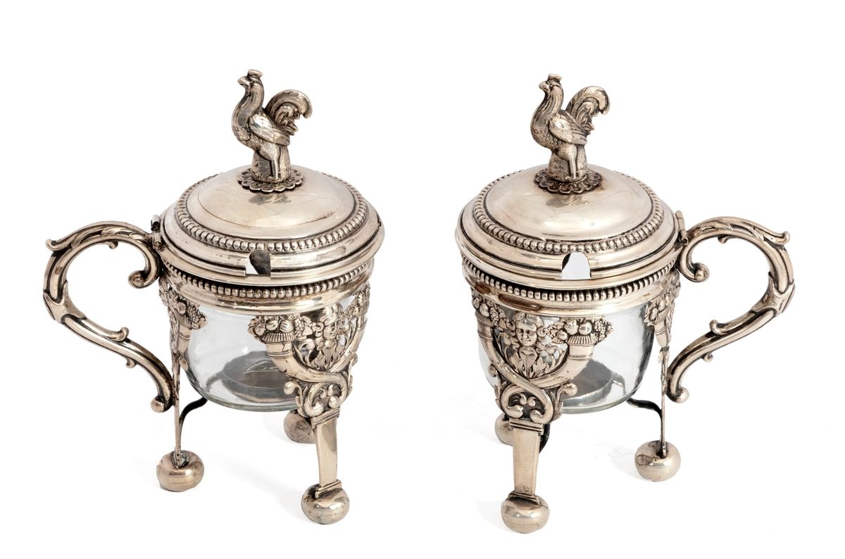 Null 一对帝国风格的银制芥末罐，装饰着丰饶的角和女性面具，公鸡形式的网状结构。
19世纪的欧洲作品。无印记。
高度：15厘米
不包括玻璃器皿的重量：224克&hellip;