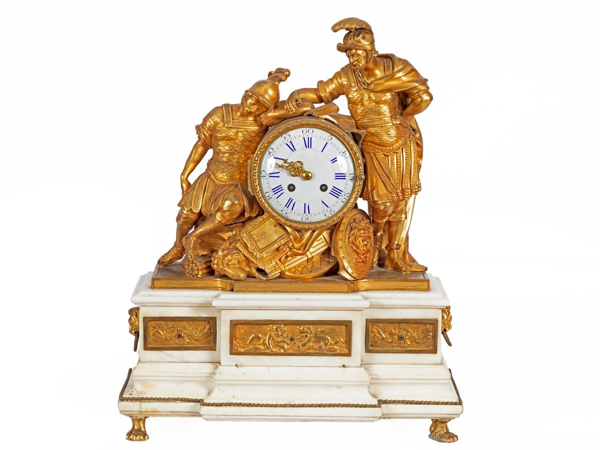 Null 一个镀金的青铜 "罗马士兵 "钟，在白色大理石底座上，装饰有三个浮雕的普提和狮子头，站在四个爪脚上。
18世纪的作品，路易十六时期。
高度：50厘米
&hellip;