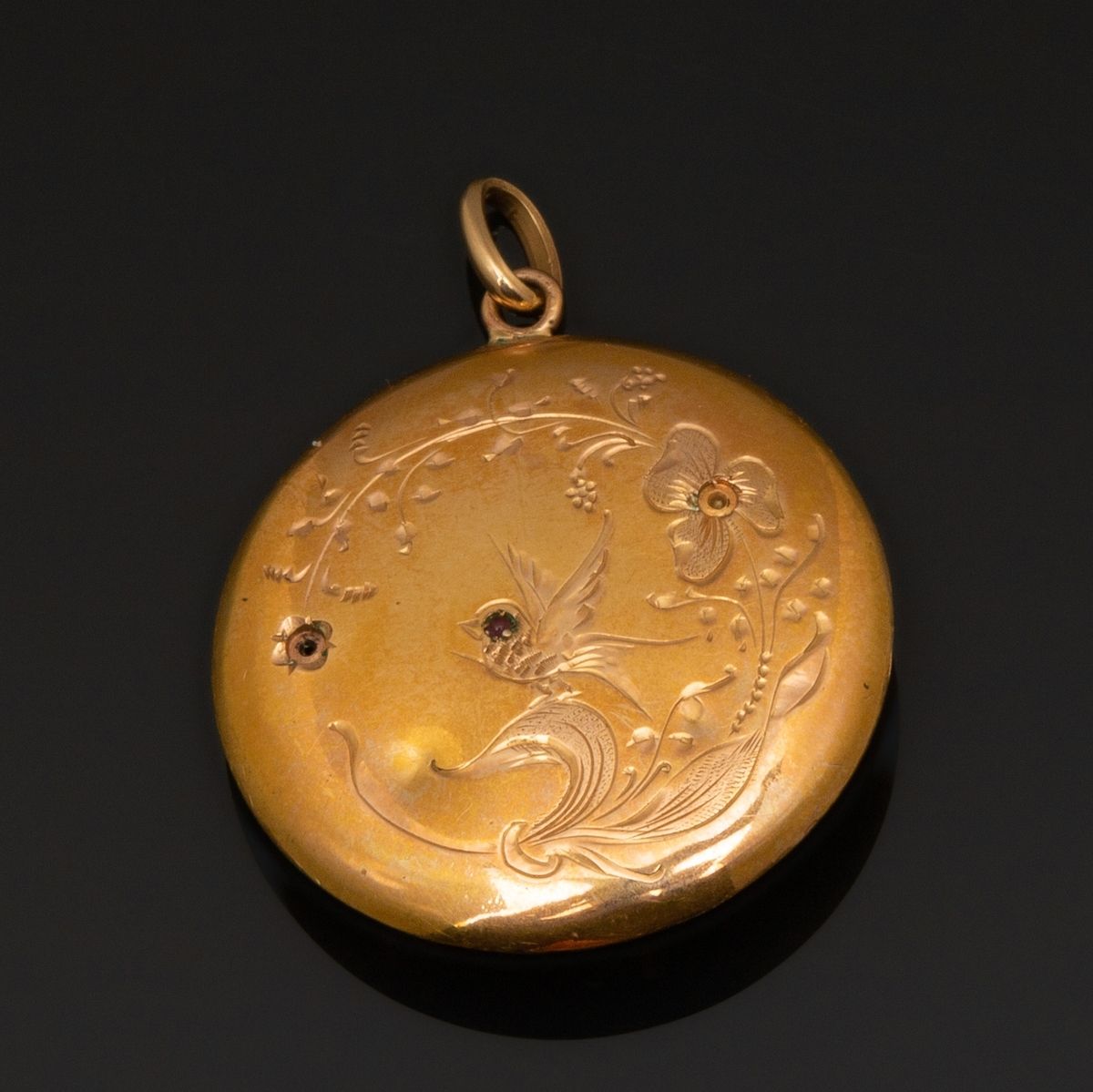 Null 20世纪初的18K黄金（千分之七十五）圆形空心纪念章，上面刻有典型的爱情珠宝的紫罗兰图案。两颗小珍珠不见了。小的缺失和凹痕。
直径：2.8厘米。
毛重&hellip;