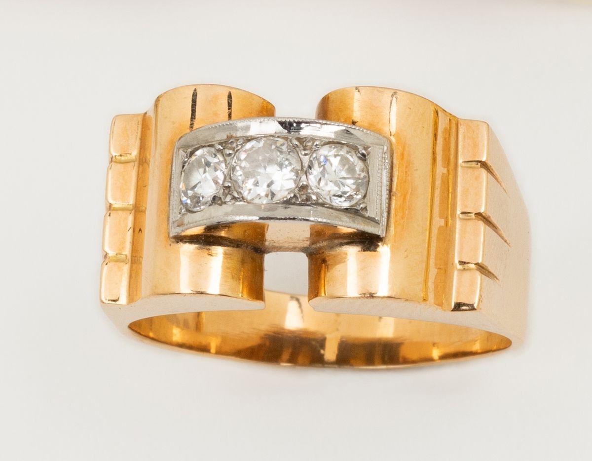 Null 一枚18K（750K）黄金和白金装饰艺术风格的坦克戒指，肩部有锯齿，支配着一个谨慎的扇形图案。中央有三颗圆形明亮式切割钻石，约0.11至0.14克拉。&hellip;