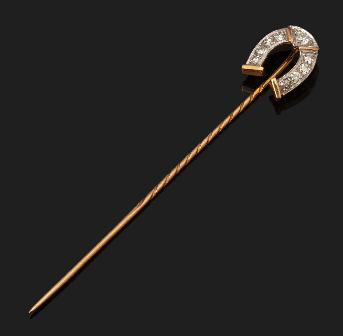 Null 18K（750千分之一）黄金和白金的领带针，其头部代表一个铺有8x8钻石和圆形明亮式切割的马蹄形。
长度：6,6 cm。
毛重：1.9克。
