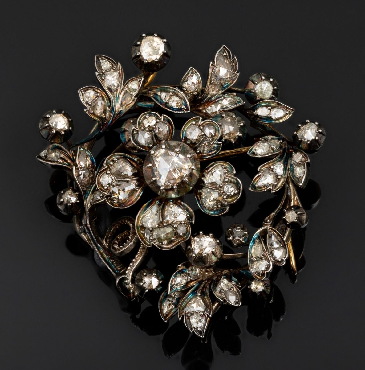 Null 十九世纪初的18K黄金（75万分之一）和银制胸针，上面有涡旋形状的花卉装饰。在中心，有一朵机械花，围绕着中央的钻石这个枢轴转动。荷兰玫瑰式切割钻石和一&hellip;