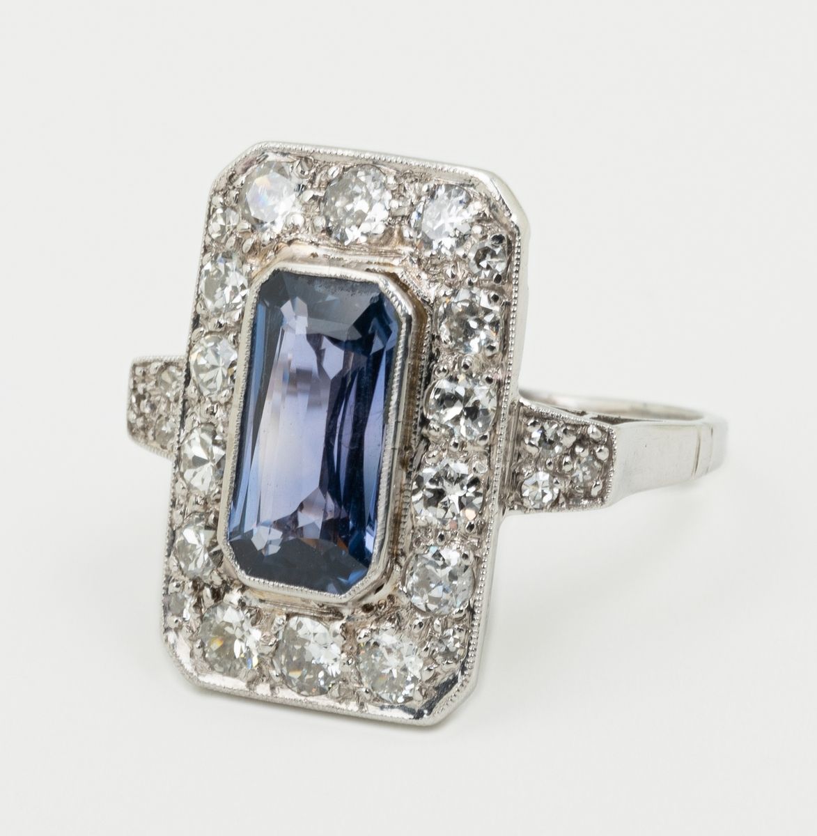 Null 一枚长方形的铂金装饰艺术戒指，镶嵌着一颗美丽的变色蓝宝石，可能是天然的，重约2.5克拉，具有很好的纯净度。在放大镜下，可以看到针状的包裹体。一行圆形明&hellip;