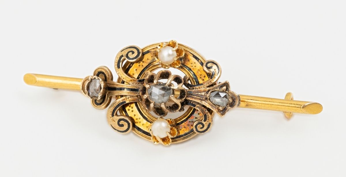 Null 一枚19世纪18K黄金（750千分之一）的胸针，中央有一个卷轴图案，其边缘有精细的黑色边框（缺失）和玫瑰切割钻石的珐琅。
长度：4.5厘米。
毛重：4&hellip;