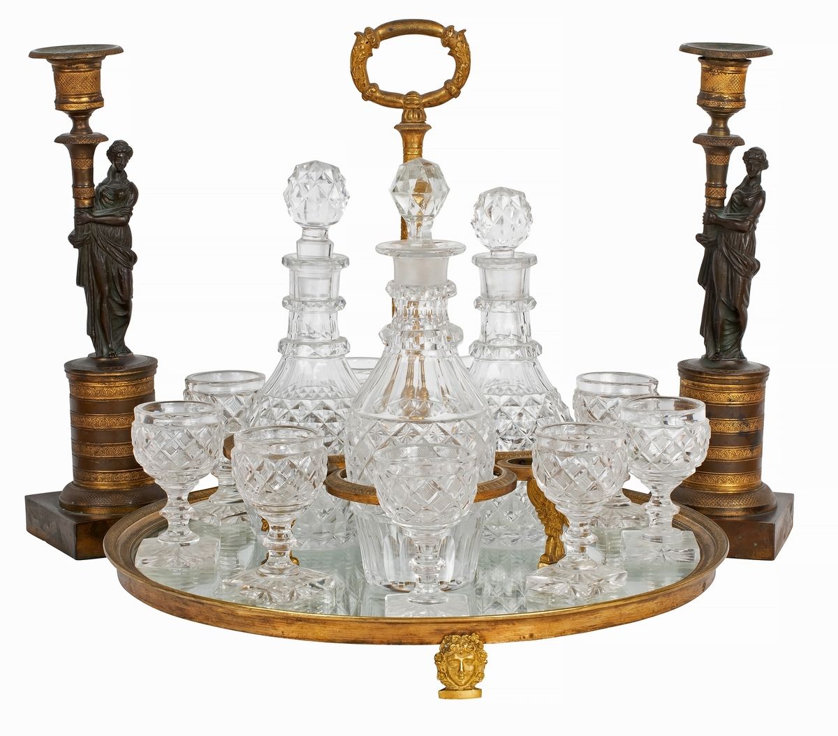 Null 一对帝国风格的青铜烛台，有两种颜色，装饰着手持火炬的妇女，一个帝国风格的镀金青铜中心器，装饰着天鹅和面具，包括3个醒酒器和10个切割水晶杯。
烛台是1&hellip;