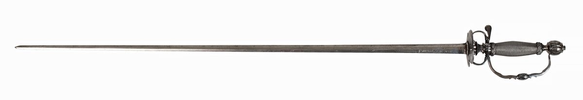 Null 18世纪中叶的英国剑，钻石切割刻面的铁座，扭曲的金属丝与扭曲的主教帽，钻石截面的剑身，第一节上有卷轴的雕刻 
总长度：92厘米
剑身长度：76厘米

&hellip;
