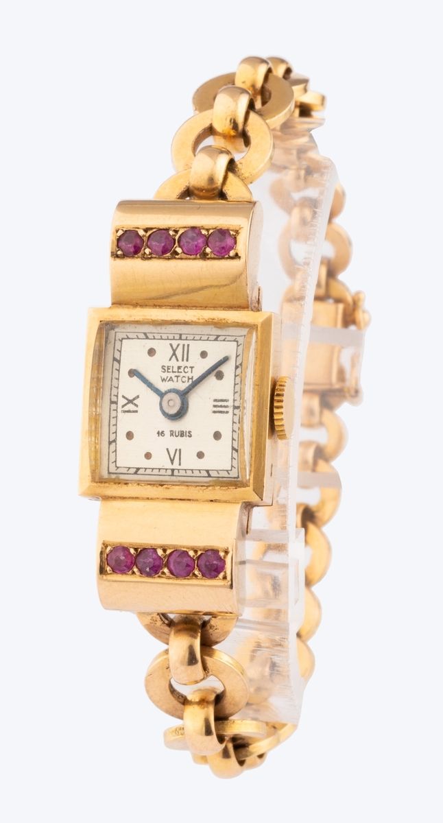 Null 选择手表
18K（千分之七十五）玫瑰金装饰艺术风格（坦克式）女士腕表。表盘上有罗马数字和蓝光指针。表壳风格化，镶有两行天然红宝石，呈现出美丽的丝绸云朵&hellip;
