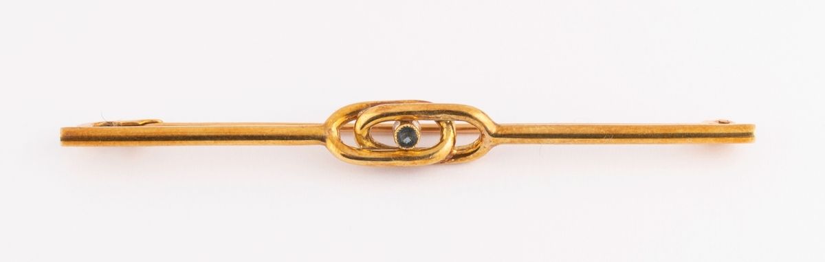 Null 18K（750千分之一）黄金lavaliere胸针，以蓝色切割玻璃为中心的美丽图形线。 
长度：约6.5厘米。 
毛重：2,7克。