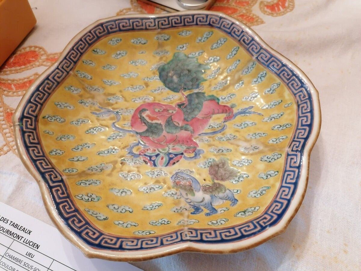 Null 中国 - 一个多裂纹瓷杯的跟部，在黄色的背景上装饰着一条龙和一条云中狗。直径：25厘米