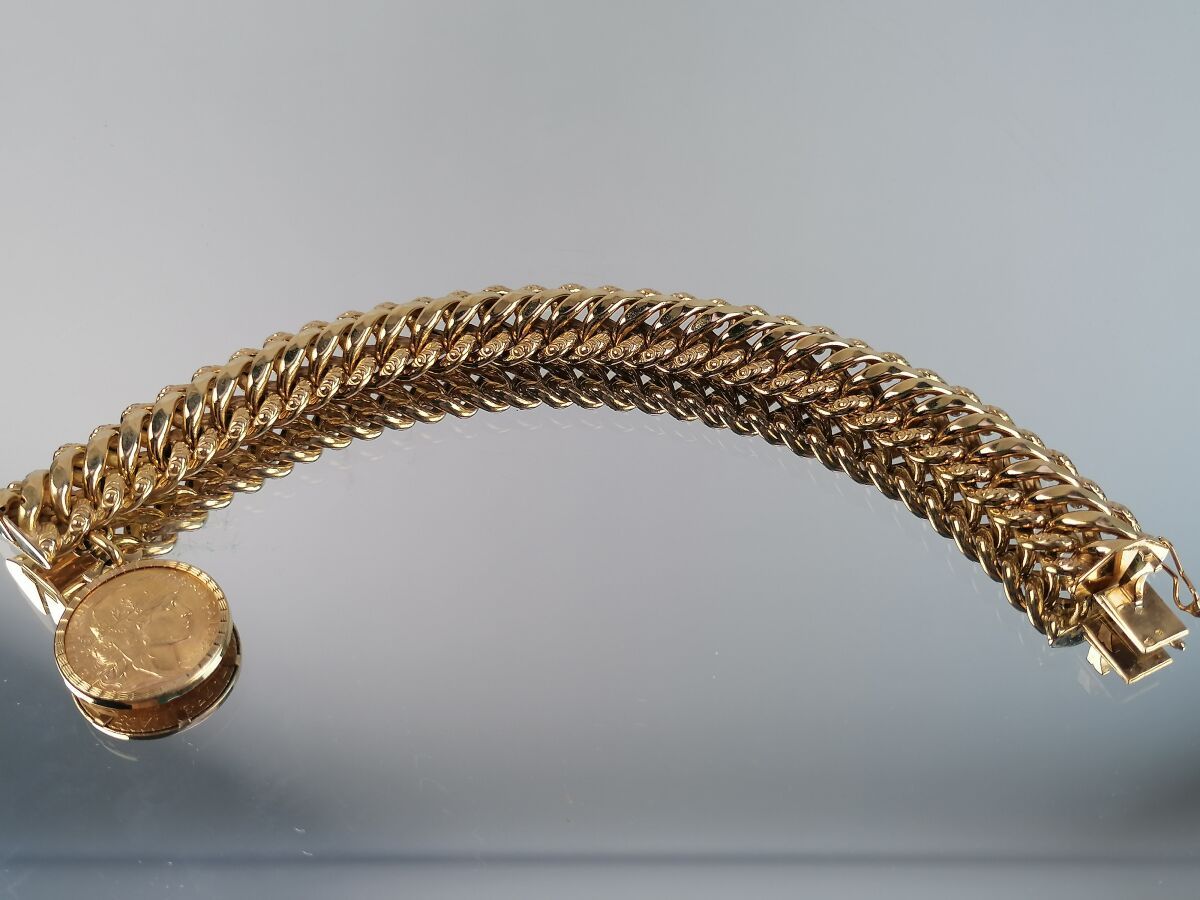 Null Bracelet en or jaune articulé orné d'une pièce de 20F or. 41,88 grs
