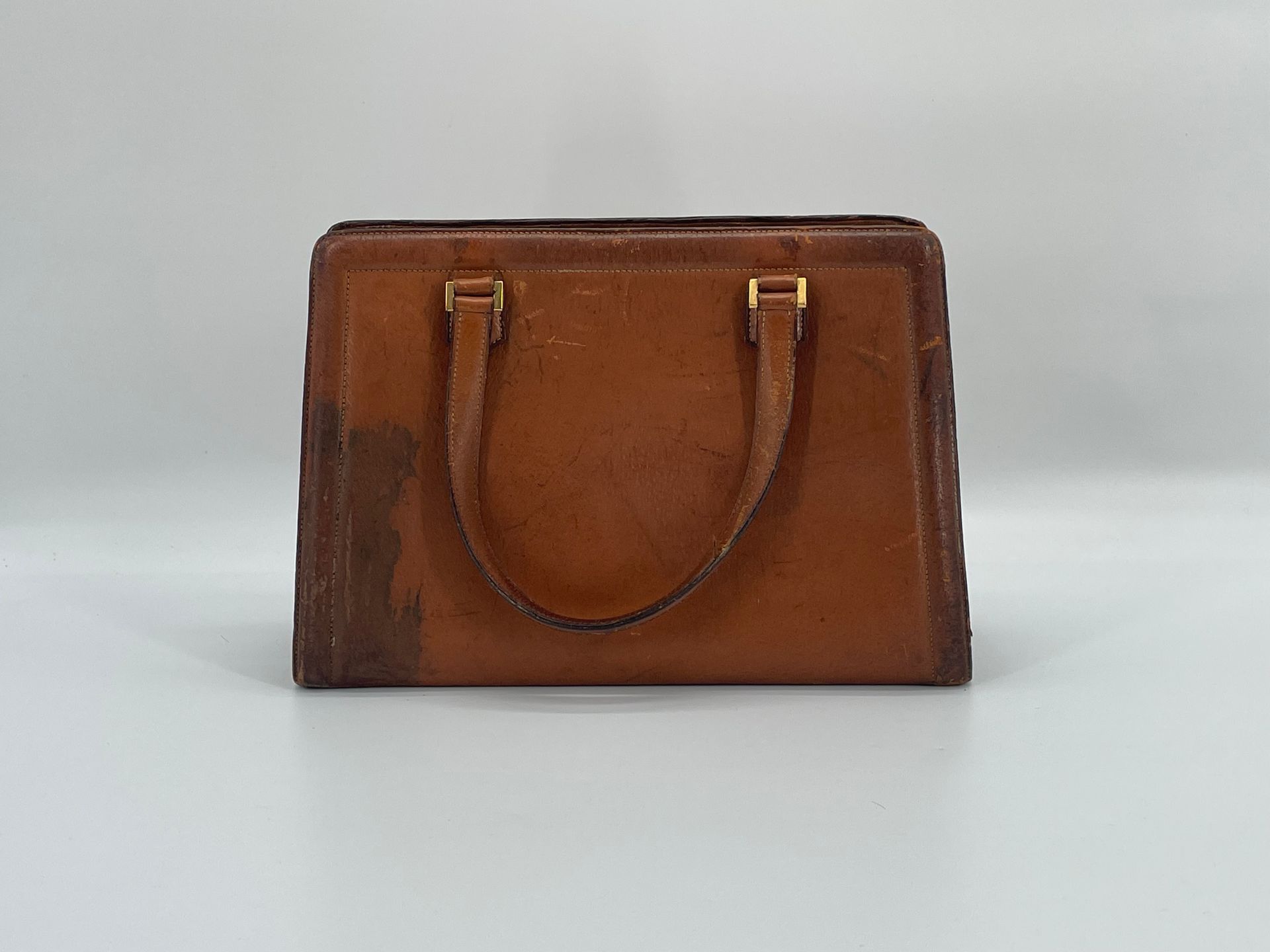 Null 巴黎赫曼斯。
哈瓦那绗缝皮革梯形手提包，有三个隔层。
约 1950-60 年。
22.5 x 32 x 9 厘米。
磨损、染色、缺失。无钥匙。