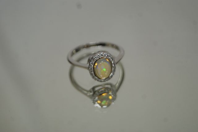 Null Silver ring 925/1000 centered with a cabochon opal in a frame of white

whi&hellip;