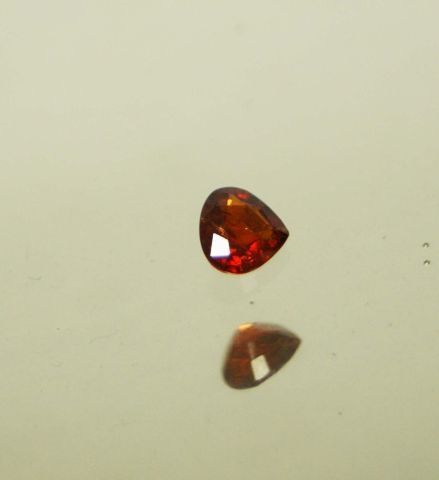 Null 1.20 carat orange heart/pear garnet on paper.