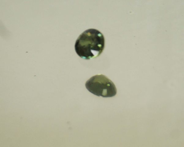 Null Schöner blau-grüner Saphir oval von 2,69 Karat auf Papier.