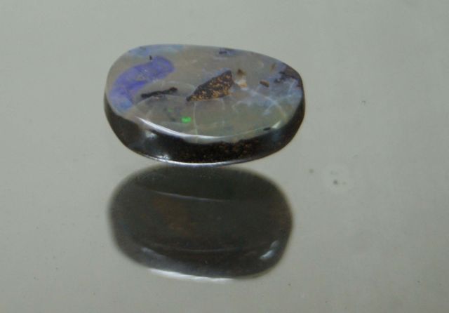 Null Brown and gold Winton opal with geometric cabochon of 6.09 carats on paper.