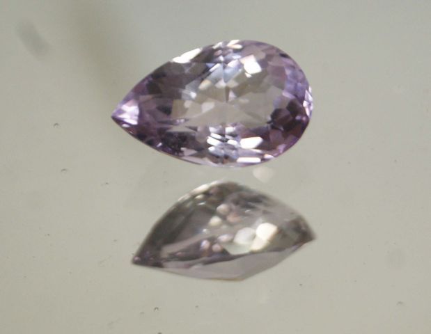 Null 重要的透明梨形切割紫水晶混在纸上。

重量 : 18,04 cts approx.