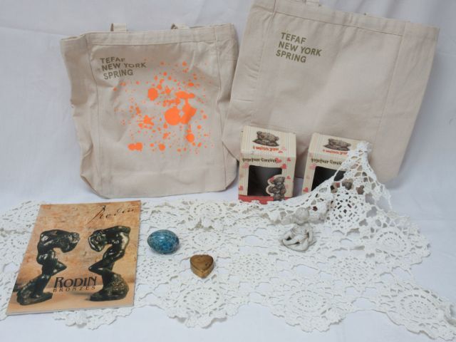 Null 拍品包括2个Tetaf帆布袋，一个桌巾，一本关于罗丹青铜器的目录，一个饼干雕塑（缺失），一个装有小铁丝人物的小铜盒和两个儿童杯。