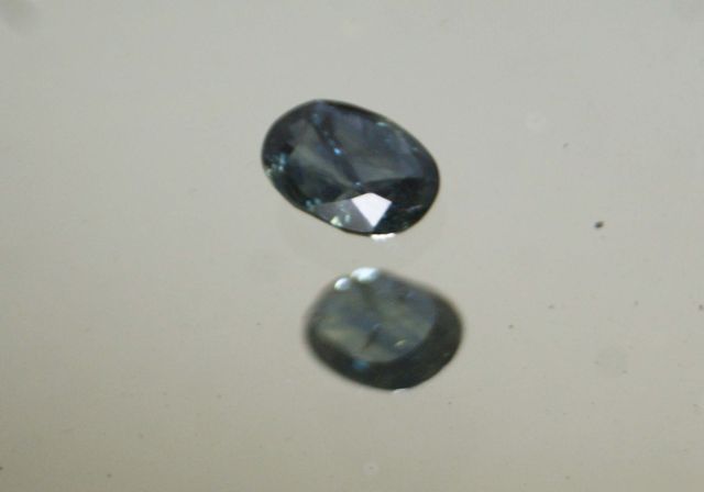 Null Blue/green oval sapphire on paper.

Inclusions.

Weight : 2,28 cts approx.