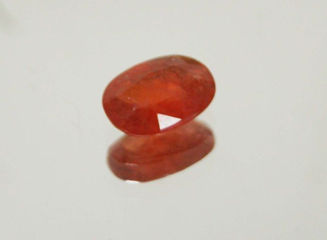 Null Oval orange sapphire on paper. 

Weight: 2.04 carats approx.