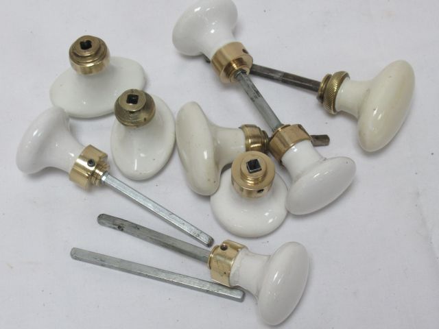 Null Set of white porcelain and brass door handles.