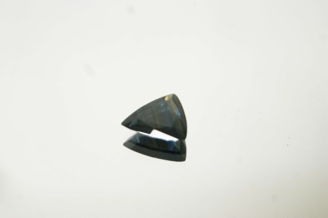 Null 扁平的三棱形切割蓝宝石在纸上。

重量：约3.04克拉