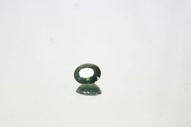 Null Saphir vert de taille ovale sur papier. 

Poids : 3,29 carats env.