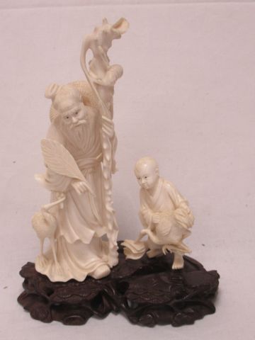 Null 一个日本的象牙雕刻组，显示一个老人和一个孩子以及两个涉水者。木质底座。高度：20厘米
