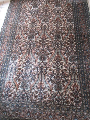 Null 伊朗基尔曼羊毛地毯，在米色背景上装饰有风格化的植物。承担了一个签名。221 x 140厘米