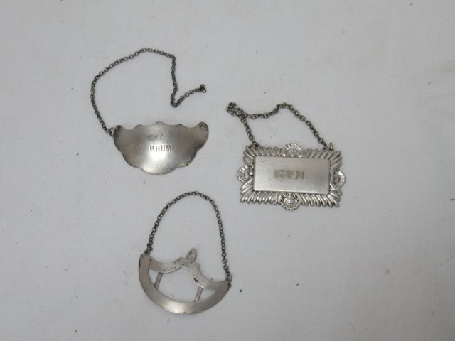 Null Lot de trois plaques de carafe en métal argenté. Une chaine à refixer. 6 cm&hellip;