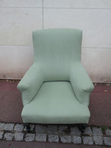 Null 舒适的 "扶手椅 "采用薄荷绿面料，靠在4条熏黑的木腿上。