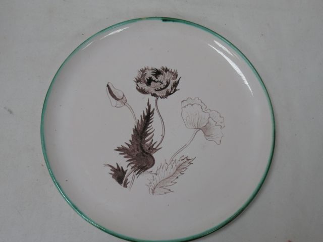Null 有植物装饰的陶器盘子，背面有签名，直径19厘米。