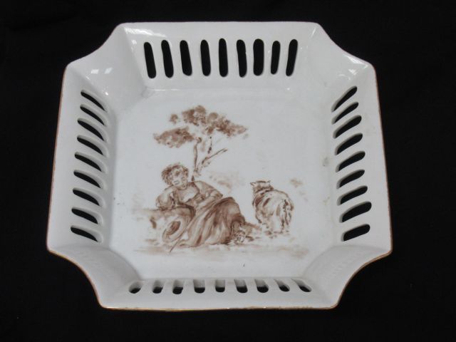 Null Plat en porcelaine à décor d'une bergère, signé Calou. 24 x 24 cm.