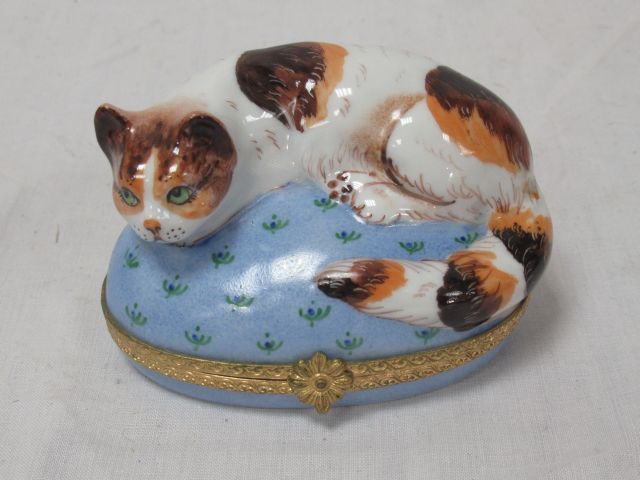 Null LIMOGES Boîte en porcelaine, à décor d'un chat couché. Monture en métal dor&hellip;
