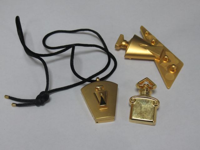 Null GUERLAIN 拍品包括两个胸针（一个丢失）和一个瓶子形状的吊坠。