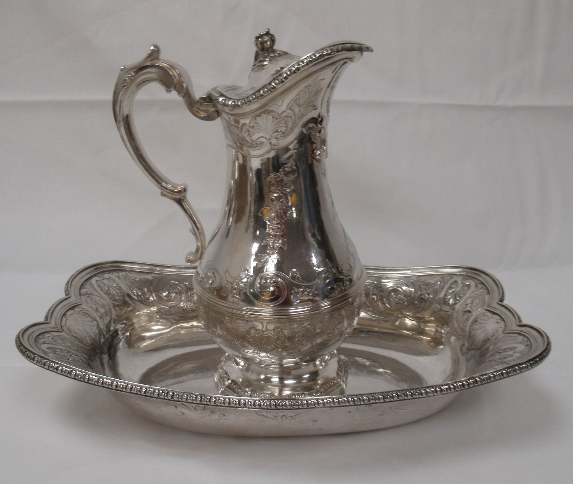Null 一个银制水壶和它的盆子，刻有花和贝壳的Rocaille装饰。18世纪（印记E冠，第戎1757？）重量：1 811克 高度：25厘米，长度：32厘米