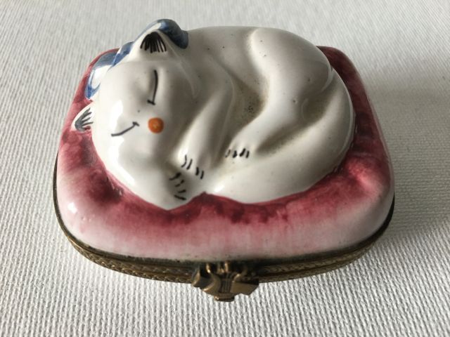 Porcelain and brass pillbox featuring a cat lying sleepi…