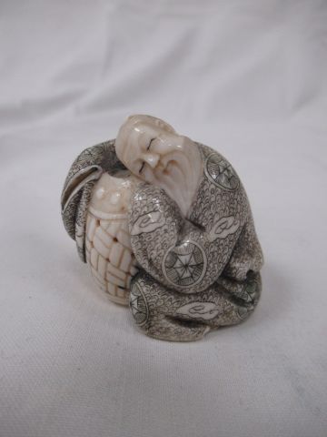 Null JAPON Figurine en ivoire, figurant un homme dormant sur un panier. Porte un&hellip;