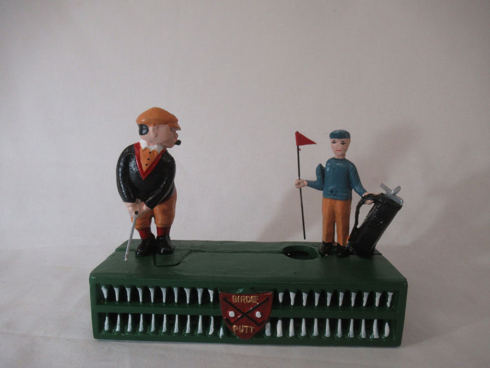 Null Piggy bank in cast iron, decorated with golfers. 14 x 20 cm