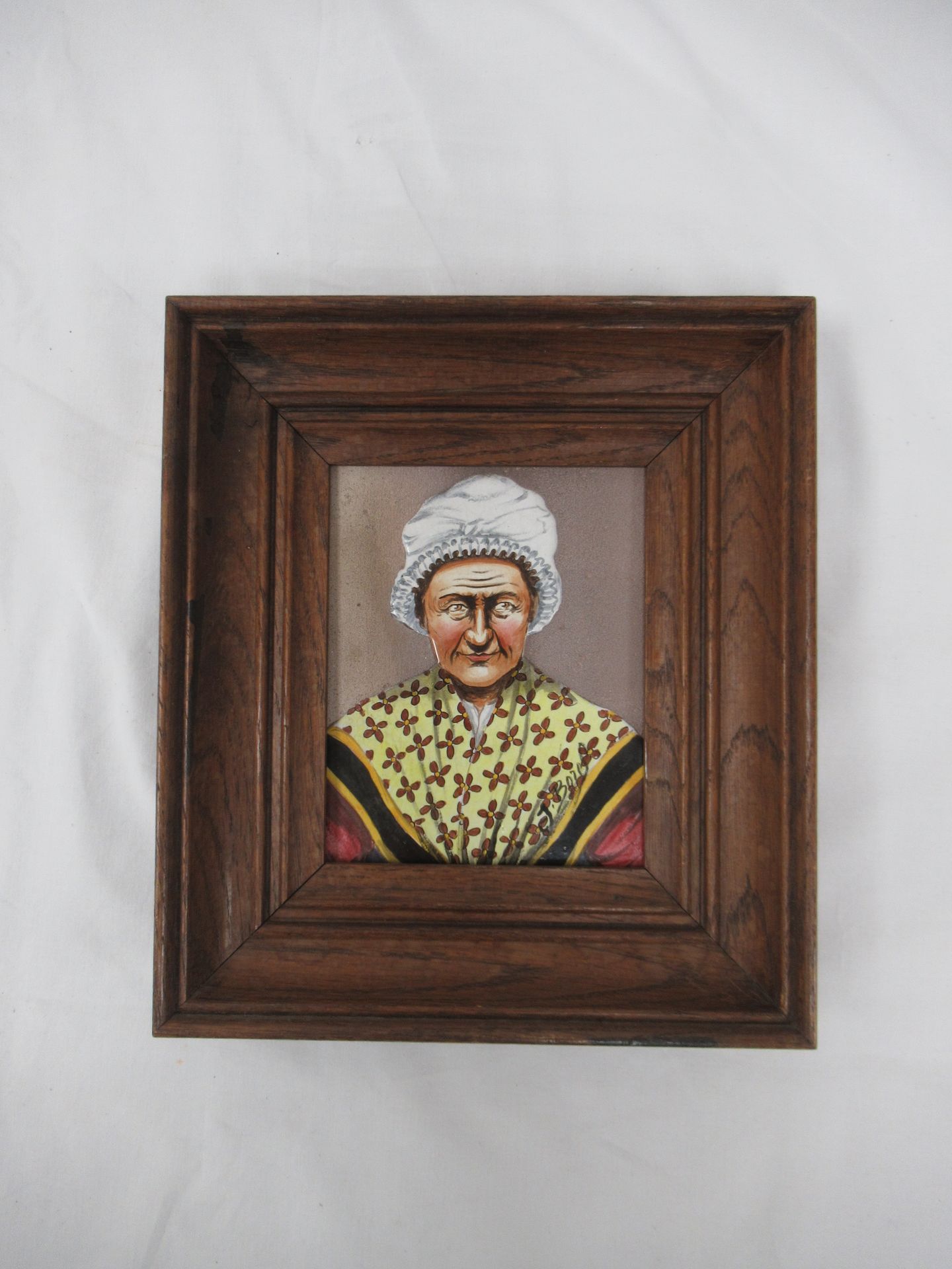 Null Plaque en céramique à décor émaillé d'une femme bretonne. 15 x 13 cm. Cadre&hellip;