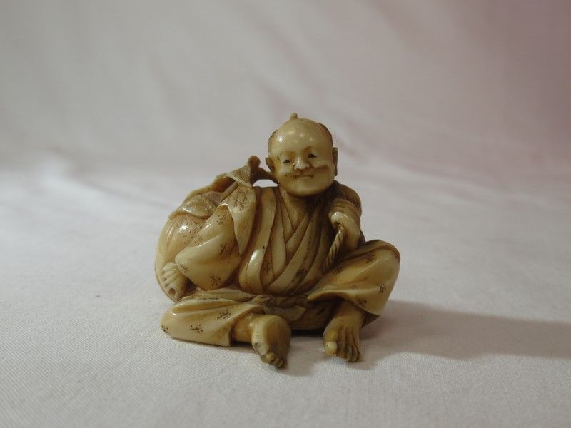 Null JAPON. Petite sculpture en ivoire figurant un homme assis. Longueur : 6 cm &hellip;