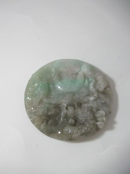 Null CHINE Pendentif circulaire en Jade figurant un dragin. Diam: 5 cm.